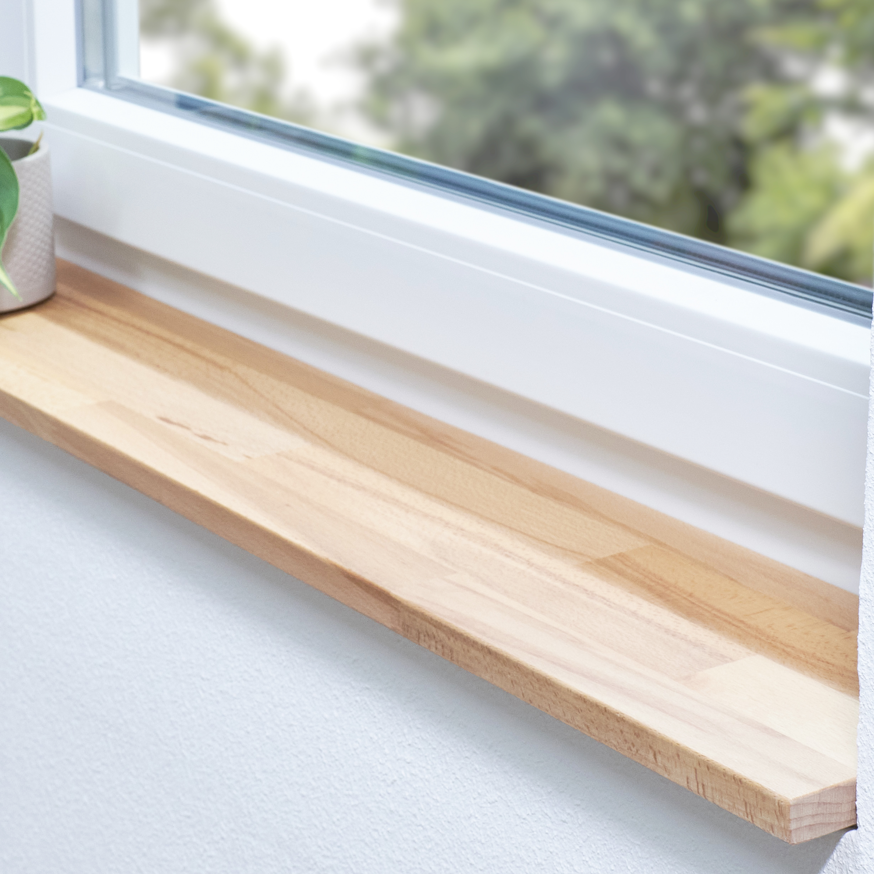 Alféizar de haya de corazón rojo natural, con unión dentada, en derrame blanco con planta en maceta y vista al verde