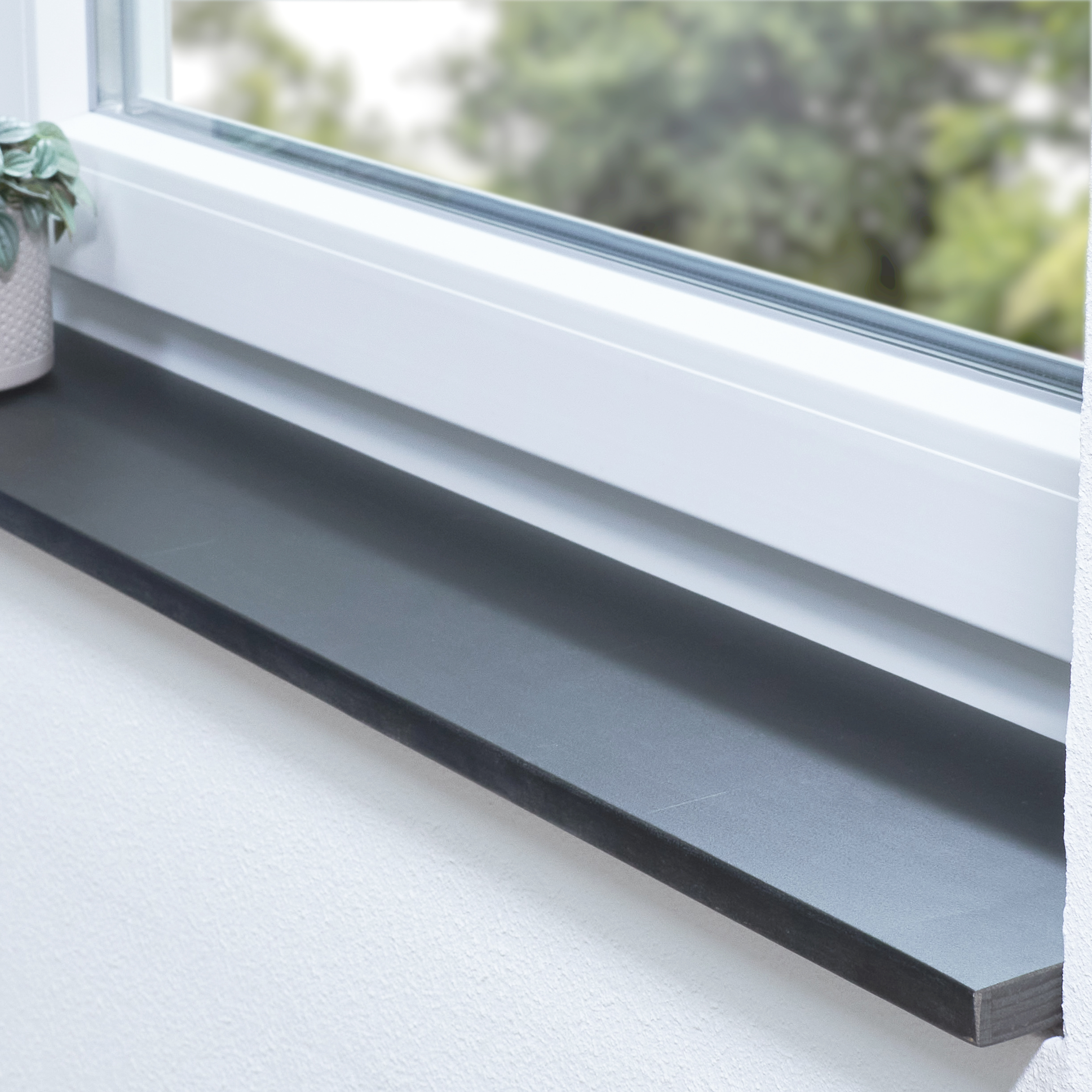 Alféizar de haya de corazón rojo teñido de negro, con unión dentada, en derrame blanco con planta en maceta y vista al verde
