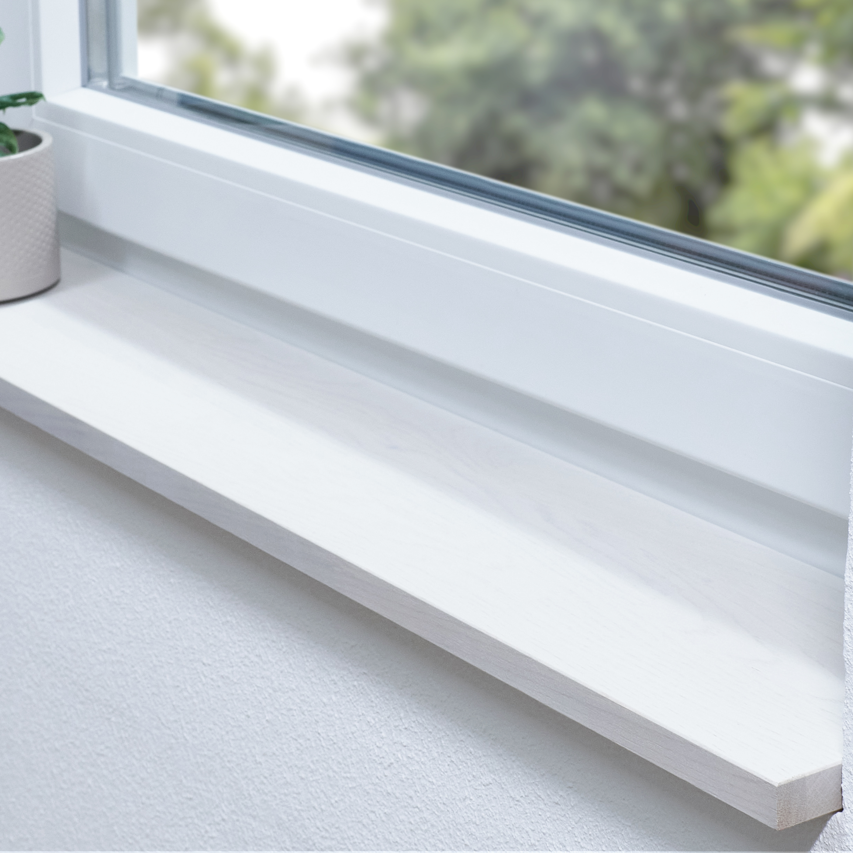 Alféizar de roble teñido de blanco con unión dentada en derrame blanco, planta en maceta al borde y vista al verde