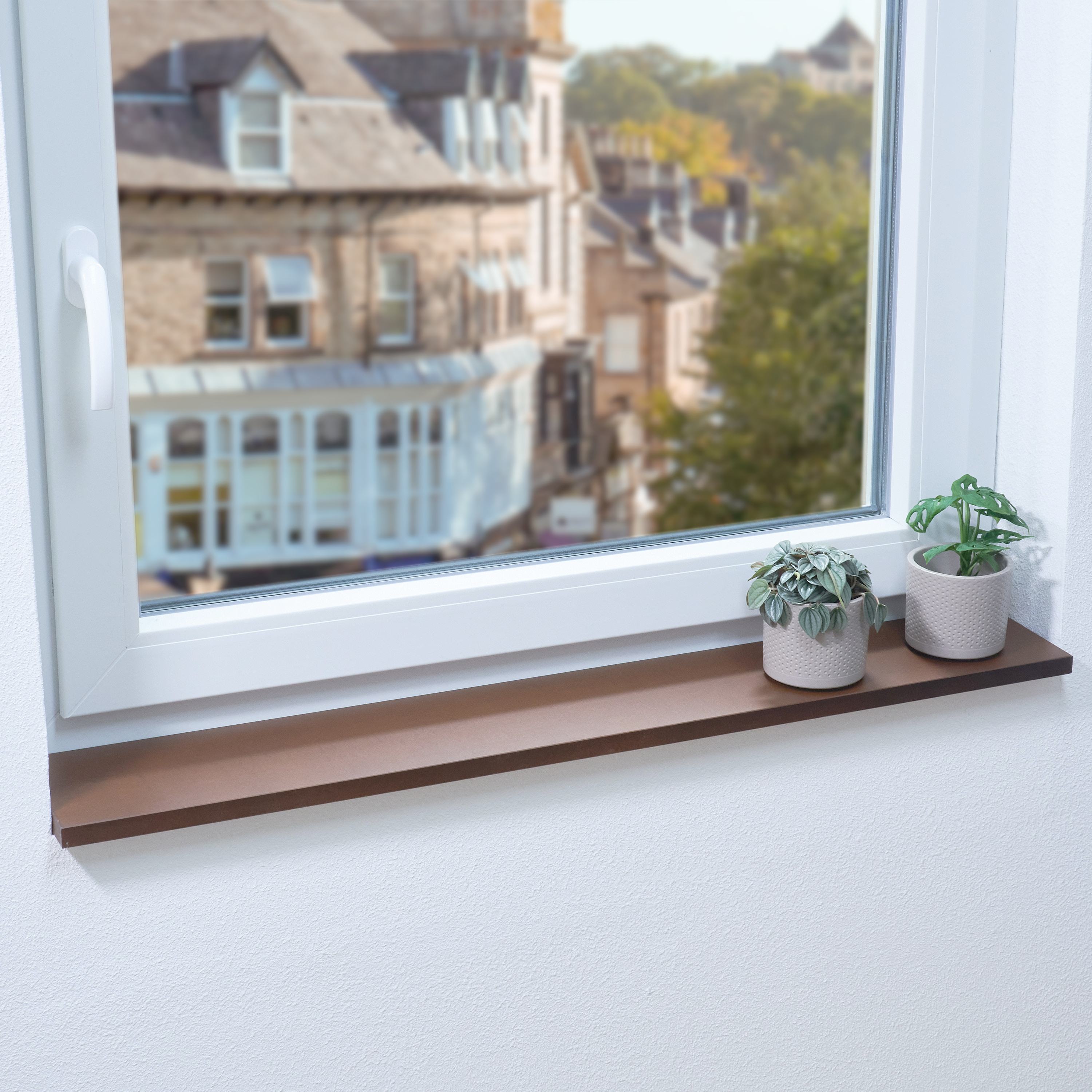 Alféizar de madera maciza marrón en ventana blanca con dos plantas en maceta, vista a casas urbanas, superficie marrón oscura
