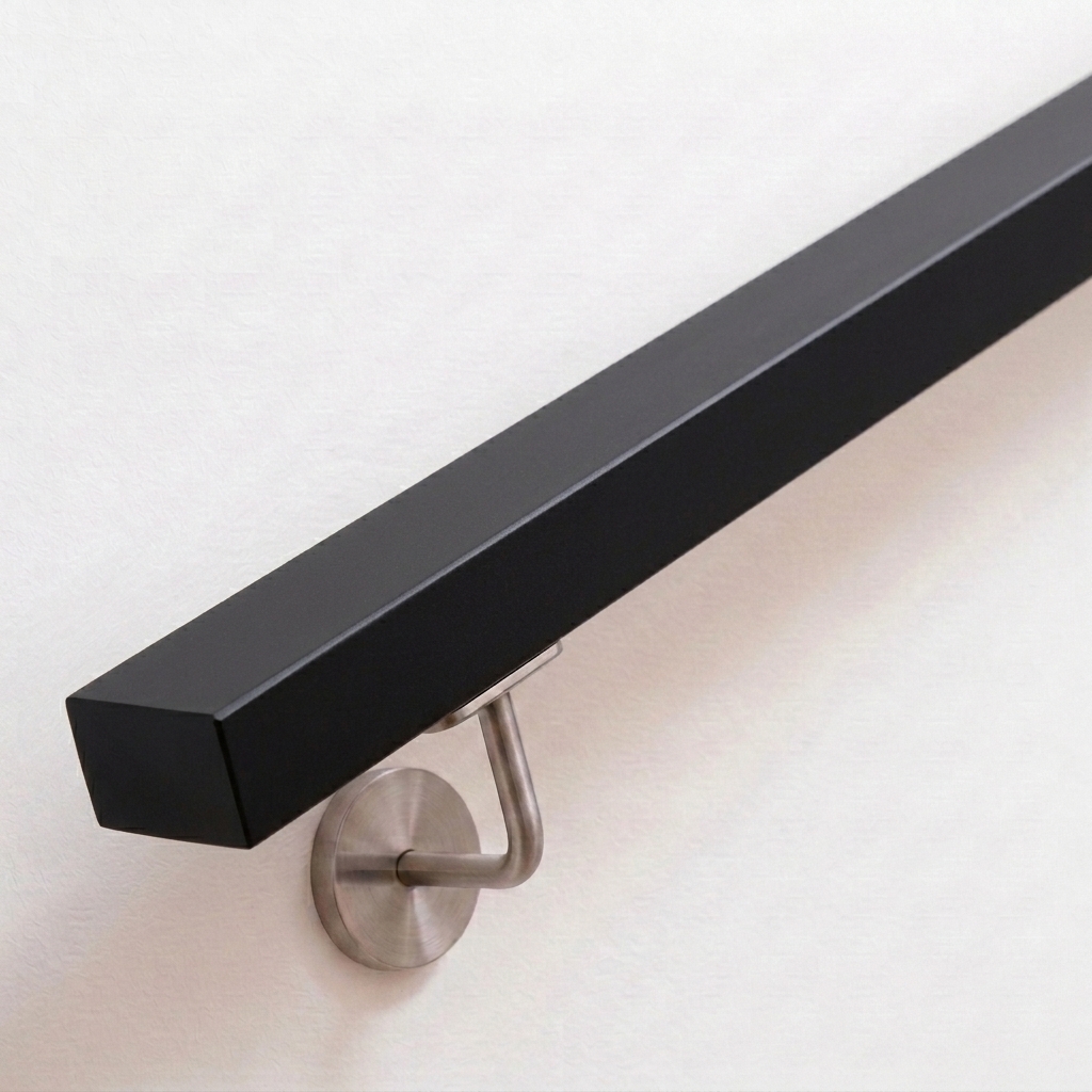 Pasamanos rectangular negro de haya lacado con soporte de acero inoxidable en pared blanca, extremo recto, vista desde arriba