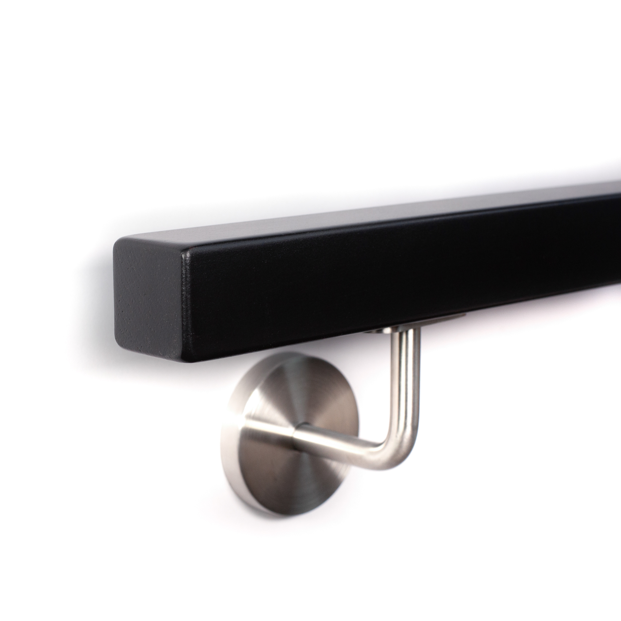 Pasamanos cuadrado lacado negro con soporte de acero inoxidable en pared blanca, primer plano oblicuo desde abajo