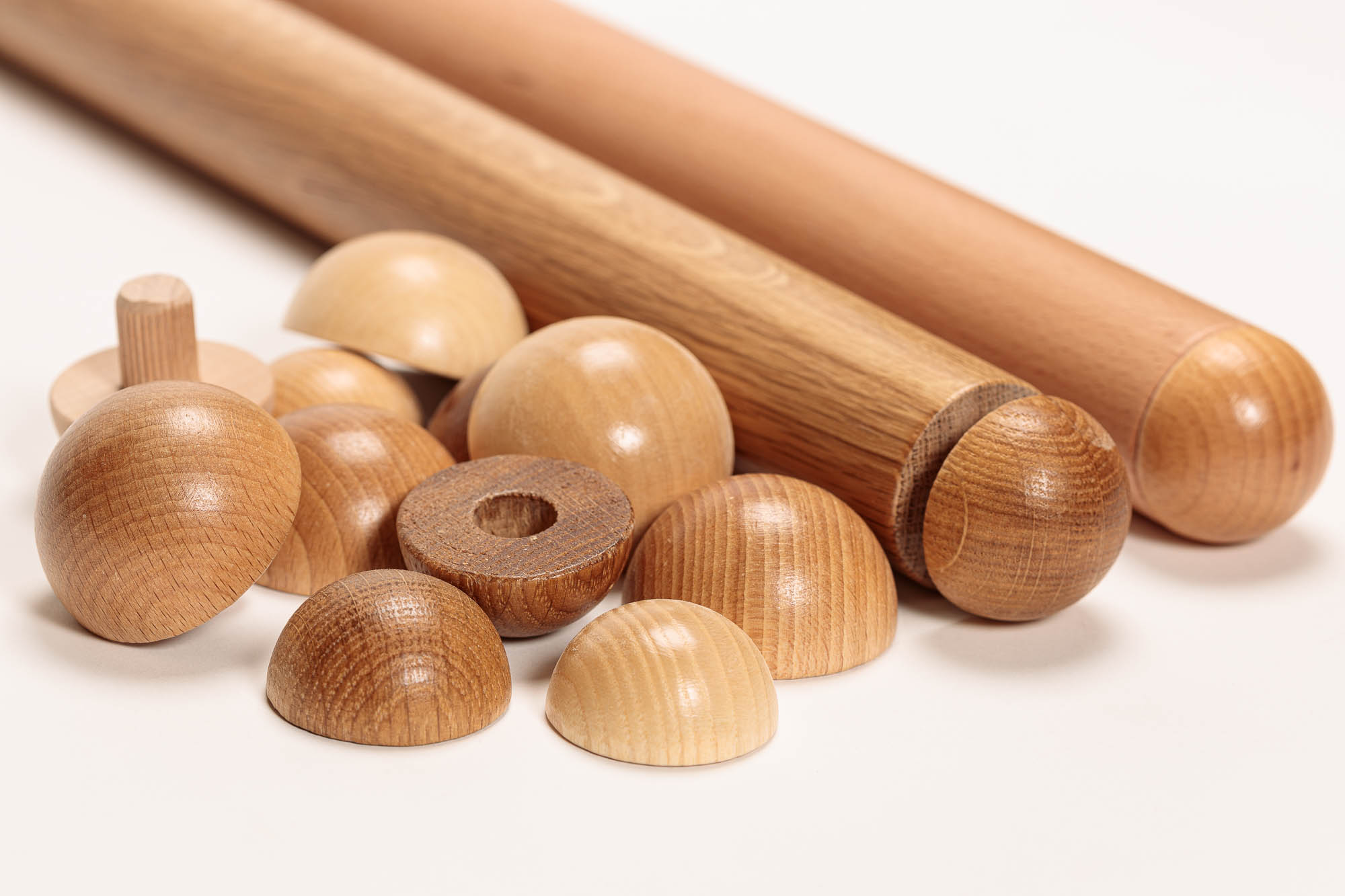 Remates de madera para pasamanos redondos en distintas maderas, semiesferas con espiga y taladro junto a dos pasamanos