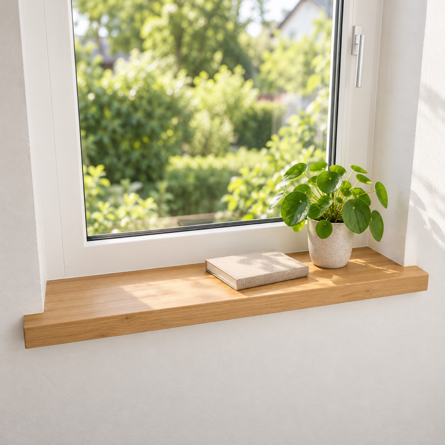 Alféizar de renovación de roble natural, madera maciza, ante ventana blanca, vista al jardín, pilea en maceta blanca y libro
