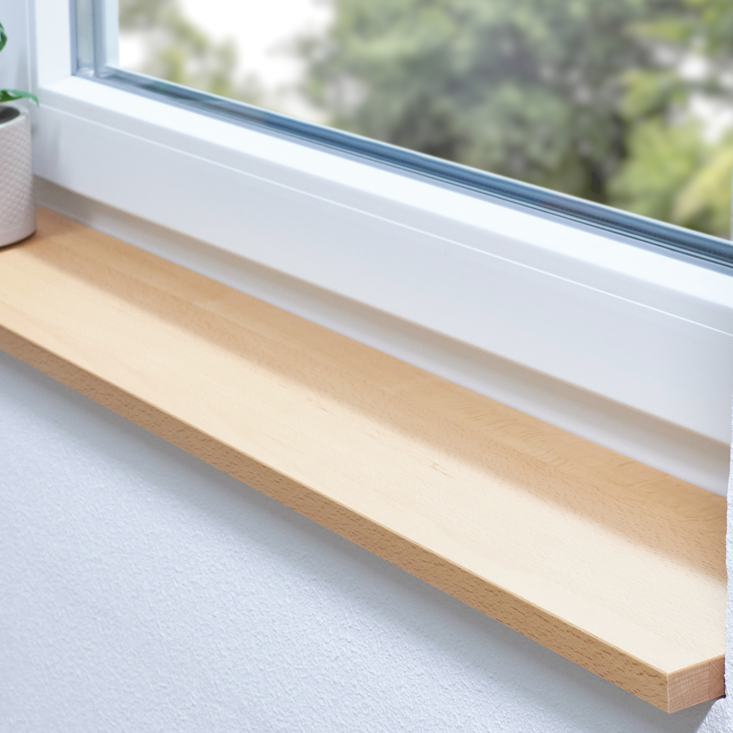 Alféizar de haya natural a medida, alféizar claro de madera maciza en el hueco de una ventana blanca con planta verde