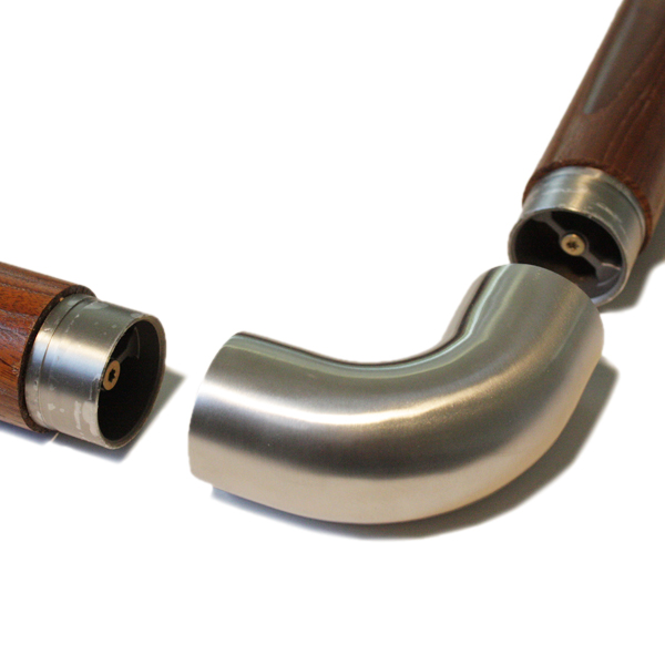 Codo de 90° de acero inoxidable entre dos pasamanos redondos de madera con piezas de unión de acero, antes de encajarlos